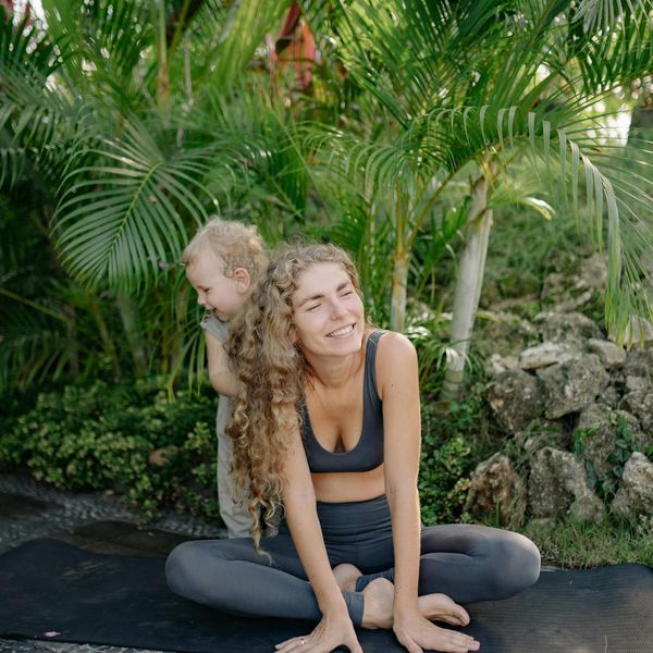 Happy child in a playful yoga pose on a colorful mat.